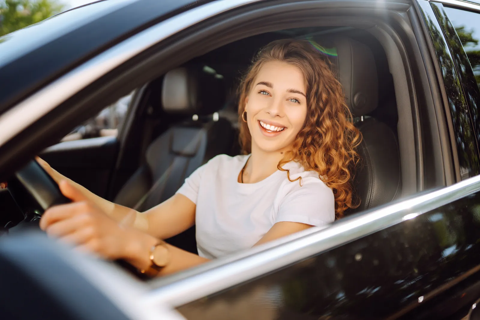 Woman driving a clean white car after a Magic Car Wash